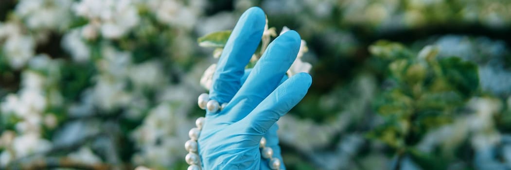 Women's hands in medical gloves and a pearl bracelet. Fashion 2020. Fashion during the pandemic. Decoration for your hands during coronavirus. Hand jewelry.