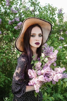 A fashionable girl with dark hair, a spring portrait in lilac tones in summer. Bright professional makeup