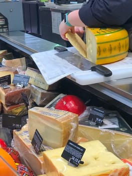 Bordeaux, France, February 9, 2024: Pieces of different cheeses in fridge in supermarket. High quality photo