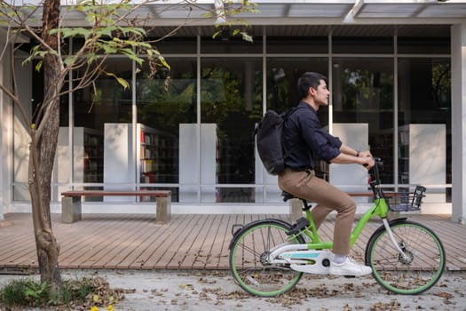 Young Asian businessman Go to work by cycling to reduce air pollution and stay healthy..