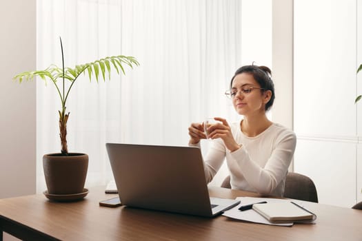 positive pretty woman working on laptop at home