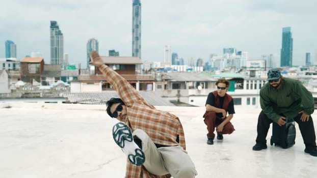 Professional hispanic break dancer practice B boy dance while multicultural friends at roof top. Young modern dancing group doing hip hop movement. Style,fashion,action. Outdoor sport 2024. Endeavor.