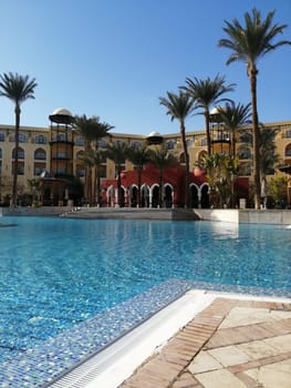 View of the pool, palm trees and the castle in Egypt - the concept of a luxury trip