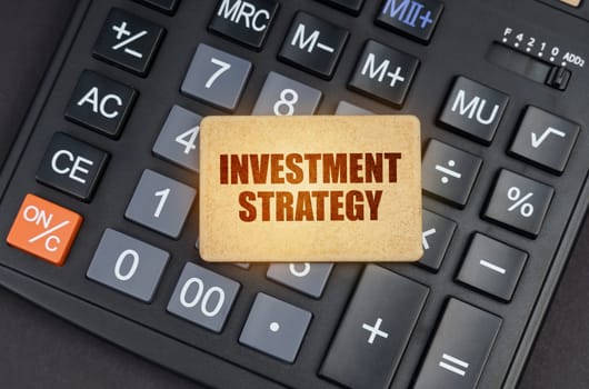 Financial concept. There is a sign on the calculator that says - Investment strategy