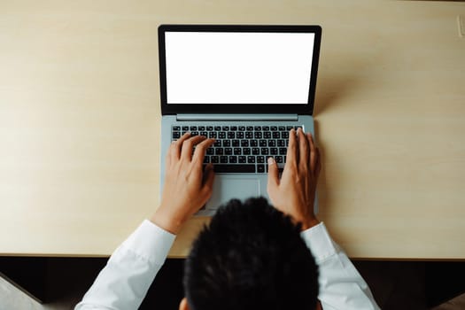 Business person or office worker using laptop computer while sitting at desk. uds