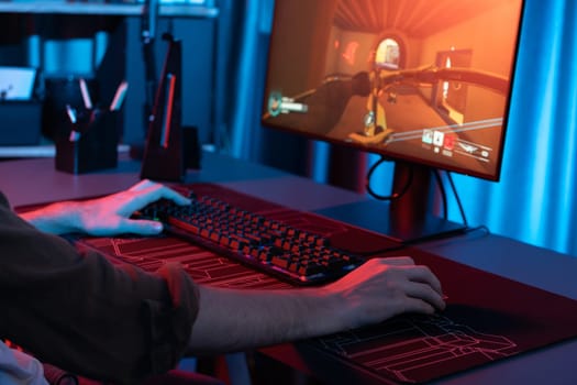 Host channel of young gaming streamer, team gamer playing battle game with multiplayer at warship on pc screen with cropped back side image, wearing headset with mic at digital neon room. Gusher.