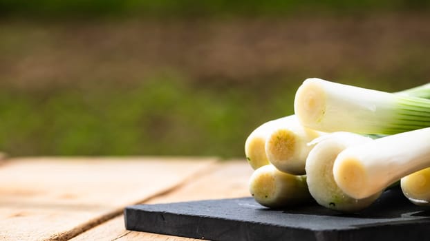 Close up of details of fresh green onions (scallion) on a cutting board isolated.