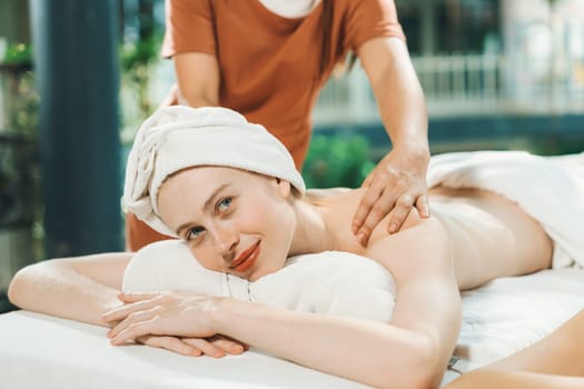 Couple of beautiful young woman lie on white spa bed during having back massage. Attractive caucasian woman having back massage at traditional spa room. Relaxing and healthy concept Tranquility.