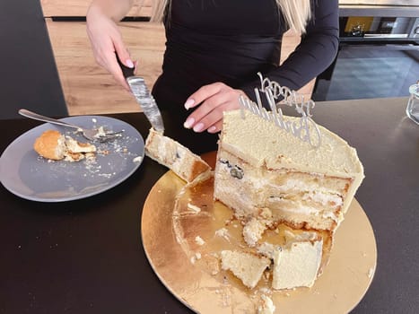 Female hands cut off a piece of festive cake with a knife. High quality photo