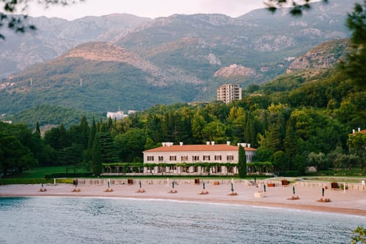 Sandy beach near Villa Milocer at the foot of high mountains. Montenegro. High quality photo