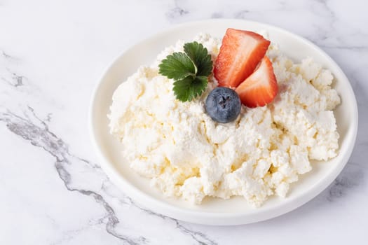 Cottage cheese with strawberry and blueberry, fresh berries, healthy breakfast concept.