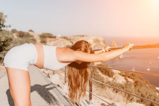 Fitness woman sea. Outdoor workout on yoga mat in park near to ocean beach. Female fitness pilates yoga routine concept. Healthy lifestyle. Happy fit woman exercising with rubber band in park.