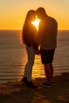 At sunset, a couple shares a tender embrace on the beach, basking in the tranquility of their holiday and the beauty of nature