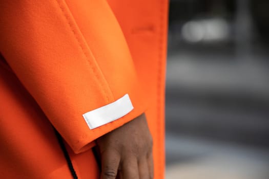 Close up texture of luxurious orange cashmere fabric on winter coat.