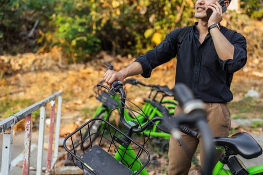 business man holding mobile using bike rental digital phone app scanning qr code to rent electric bicycle in city.