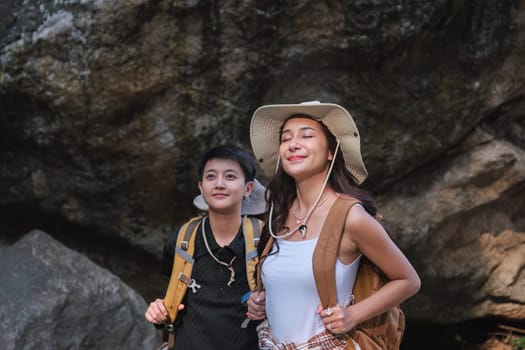 An Asian couple spent their vacation hiking along nature trail, visiting waterfall and enjoying forest views together..