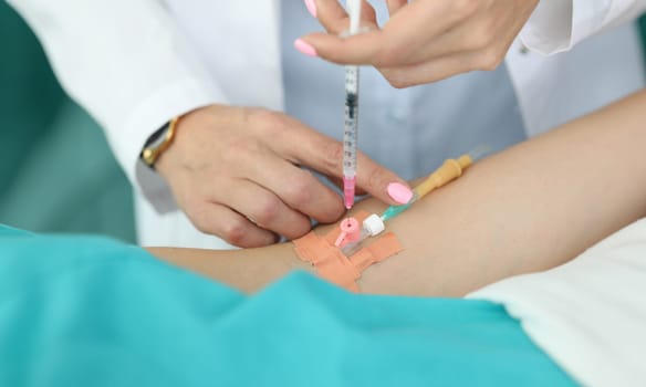 Female doctor injects medicine into patients vein. Medical care in hospital is provided with assistance specialized specialists. Preoperative preparation. Appearance allergic reactions