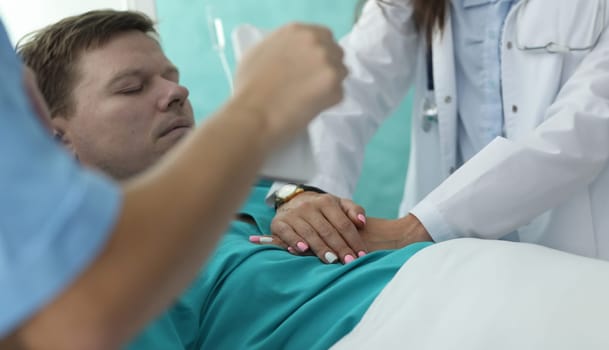 Hands nurse doing heart massage to man in clinic. Diagnosis and treatment cardiovascular diseases. Verification diagnosis heart failure. Professional team doctors provides qualified emergency care