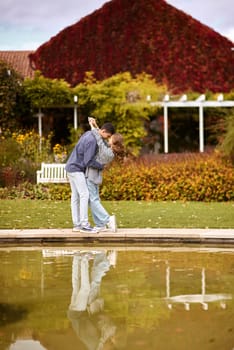 lovely young couple kissing outdoors in autumn. Loving couple walking in nature. Autumn mood. Happy man and woman hugging and kissing in autumn. Love. Fashionable couple outdoors. Fashion, people and lifestyle. Stylish couple in autumn outfit.