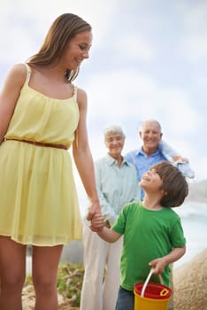 Family, mom and kid holding hands on beach for vacation, adventure and tropical holiday in Australia. Grandparents, mother and happy face of boy child at ocean with love, weekend and smile in summer