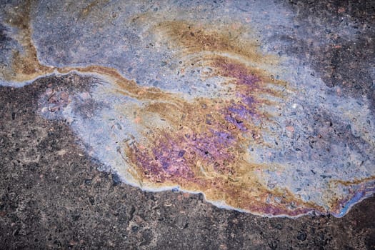 photography close-up of the asphalt road, which leaked old black oil from the car.