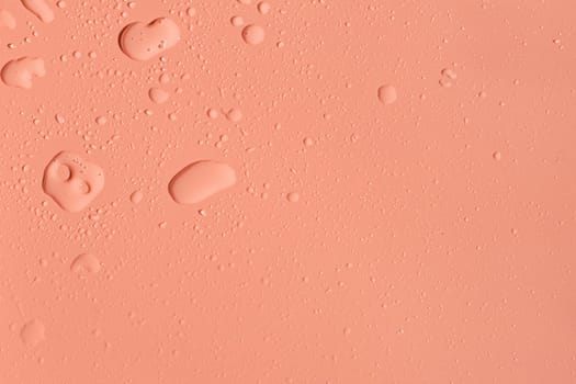 Beautiful pink background with splashes, large and small water drops, flat closeup. Concept for textures, backgrounds, wallpapers.