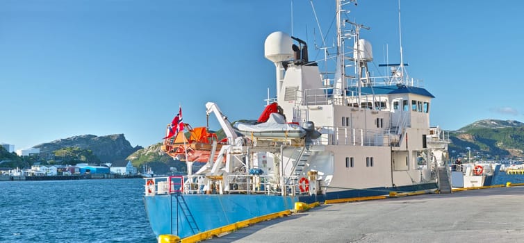 Ship, water and harbor at sea to coast guard with landscape, blue sky and transportation for emergency sailing. Vessel, dock and ocean with yacht for maritime, danger and patrol in morning and nature.