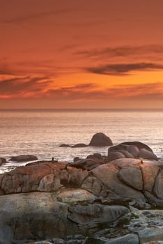 Ocean, sunset and waves on rocks on tropical island and tourism destination for summer vacation in nature. Sky, clouds and golden color on torrey pines beach, peace and outdoor travel in california.