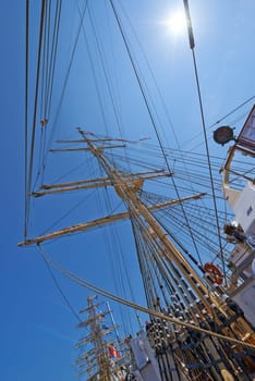 Sailing, boat and mast outdoor with flag for travel, journey and low angle of blue sky in summer. Ship, wood pole and vintage schooner vessel on a cruise, rigging and transport in nature with rope.