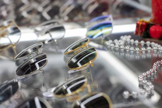 Various sunglasses on a glass shop window close up