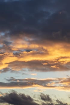 Bright yellow clouds at sunset in sky close up