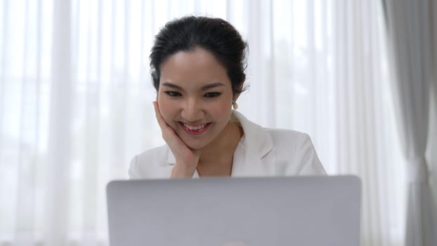 Young businesswoman sitting on the workspace desk using laptop computer for internet online content writing or secretary remote working from home. Vivancy