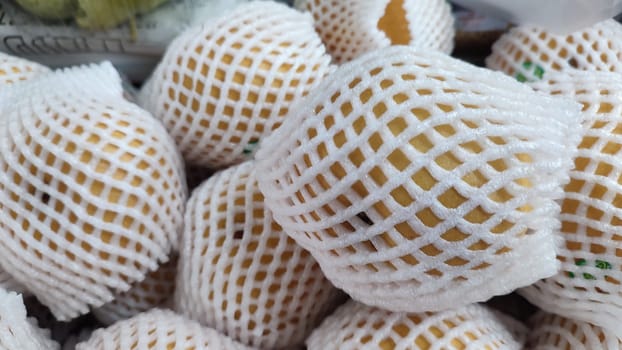 yellow fruits fruits in a white synthetic material mesh. High quality photo