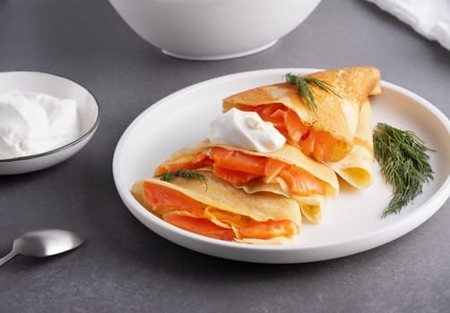 Pancakes with salmon, sour cream and greenstuff. Thin, not sweet blinchiki stuffed with red fish. Feast of Maslenitsa.