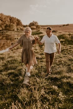 happy married couple mature people together for long time, secret of strong family relationships, cheerful joyful husband and wife together in harmony. middle-aged couple walking in nature at summer