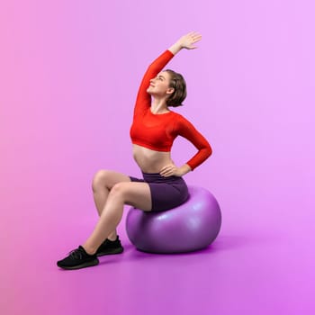 Full body length gaiety shot athletic and sporty young woman with fitness exercising ball in standing posture on isolated background. Healthy active and body care lifestyle.