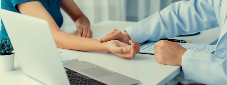 Patient attend doctor's appointment at clinic or hospital office. Doctor discusses medical treatment option, examining and diagnosis symptoms while checking the patient's pulse. Panorama Rigid