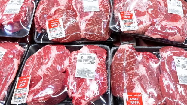 Denver, Colorado, USA-February 28, 2024-At Sam’s Club, a variety of premium Angus beef steaks are showcased, each sealed in plastic and priced, ready for customers to select for their next gourmet meal or barbecue.