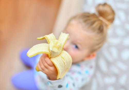 Girl holds banana in her hands