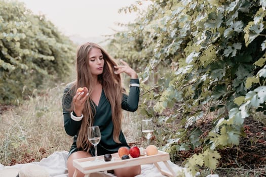 Picnic and wine tasting at sunset in the hills of Italy, Tuscany. Vineyards and open nature in the summer. Romantic dinner, fruit and wine.