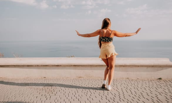 silhouette of a happy woman who dances, spins and raises her hands to the sky. A woman is enjoying a beautiful summer day.