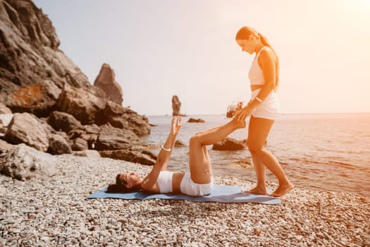 Woman sea yoga. Back view of free calm happy satisfied woman with long hair standing on top rock with yoga position against of sky by the sea. Healthy lifestyle outdoors in nature, fitness concept.