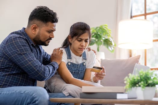 A young couple is stressed over credit card charges used for online purchases..