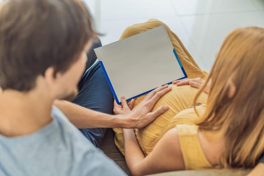 A pregnant wife and her husband are writing on a piece of paper. The paper is free for your inscriptions. copy space.