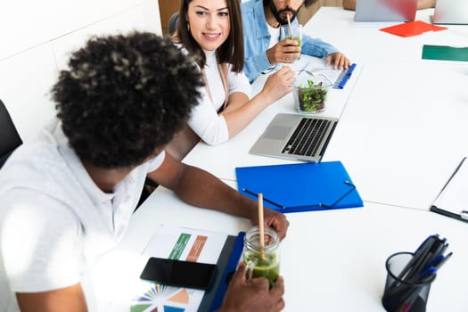 Young adult coworkers have lunch break together while working on a project. Startup concept. Business concept.