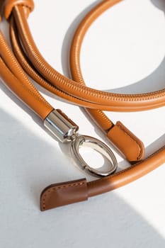 Brown genuine leather bag strap or handbag handle isolated on white background. High-quality material with a unique knot design adds style and elegance to your bag. Perfect accessory for any occasion.
