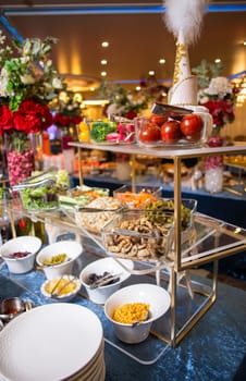 Indulge in a delectable array of salads, vegetables, and snacks, artfully presented on a buffet table. Perfect for events, parties, or gatherings. Isolated on blue background.