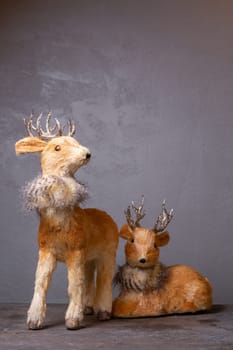 Adorable reindeer figurines with silver antlers, perfect for holiday displays, isolated on gray. Add a festive touch