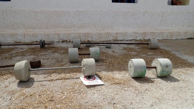 Asinara, Italy, August 11 2021. Old concrete barbells for prisoners training in the courtyard of the old prison.