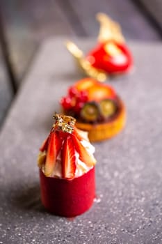 An exquisite display of four decadent slices of cake elegantly arranged on a sleek marble board, evoking a sense of culinary opulence.